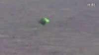 奇特的掠海飞行的绿色三角立方体UFO的图片